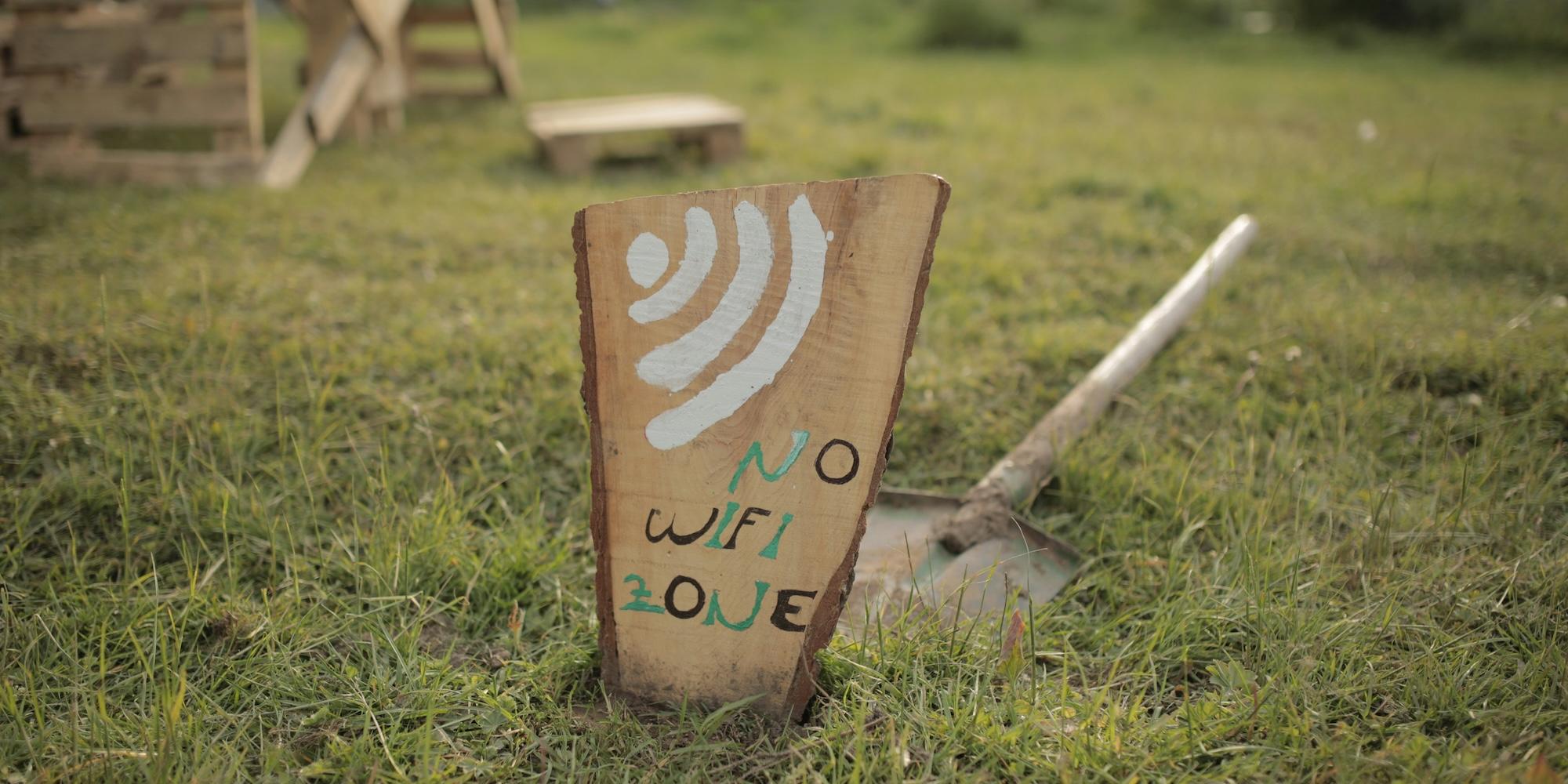 Cover image for this post: Wooden board painted with 'No wifi zone' on a grass background.