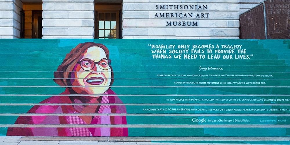 Cover image for this post: The steps of the Smithsonian American Art Museum, painted with a portrait of Judy Heumann and with the quote 'Disability only becomes a tragedy when society fails to provide the things we need to live our lives.