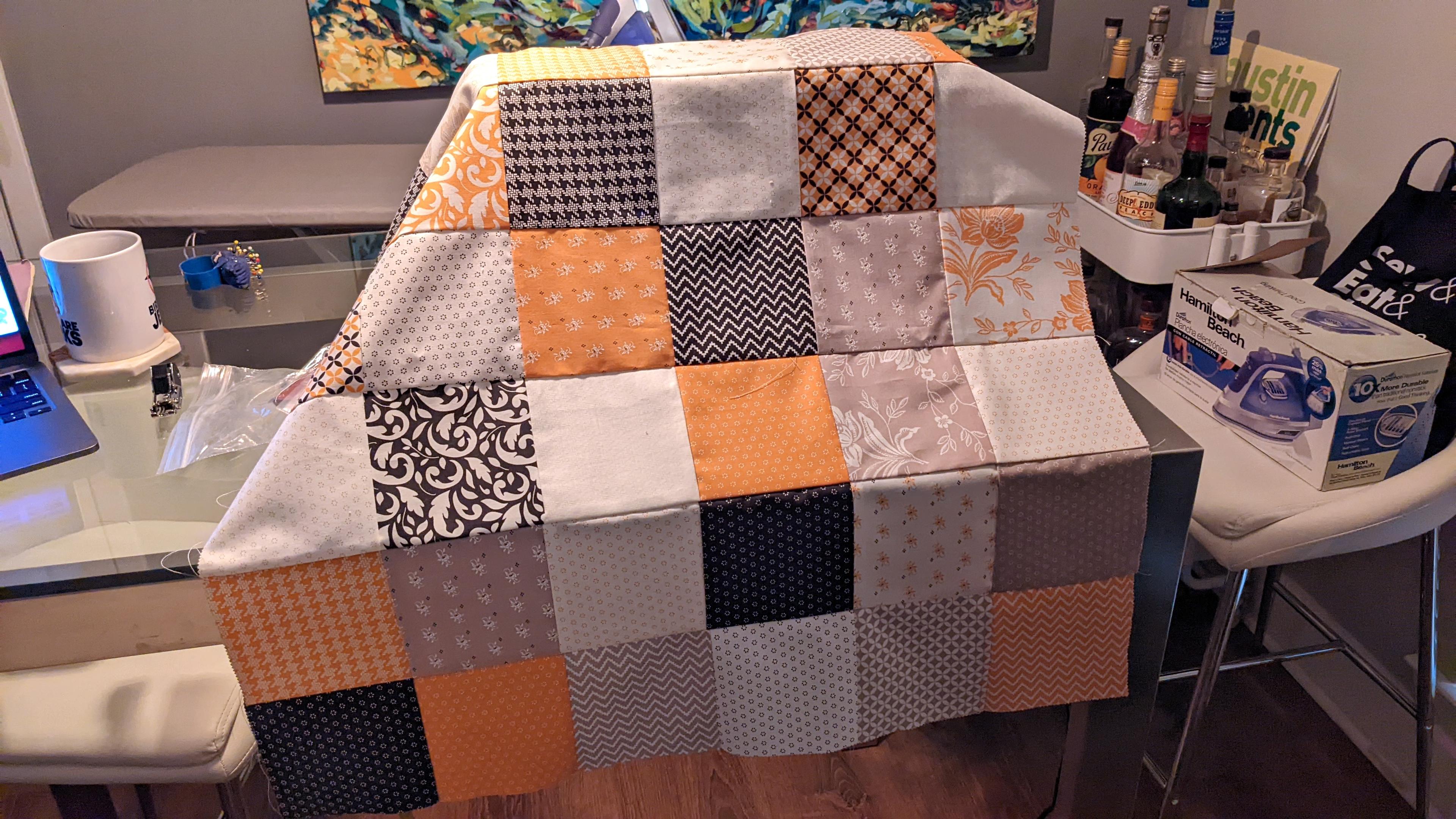 The finished quilt top, draped over the sewing machine on my dining table.