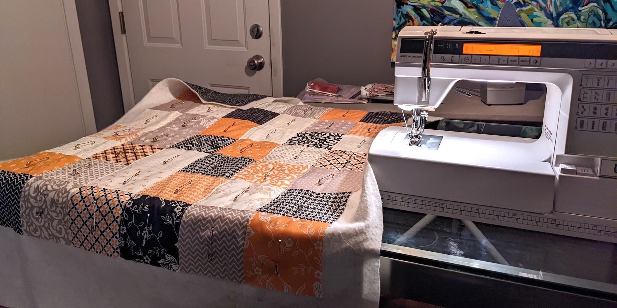Work in progress straight line quilting along the seams of the quilt top.