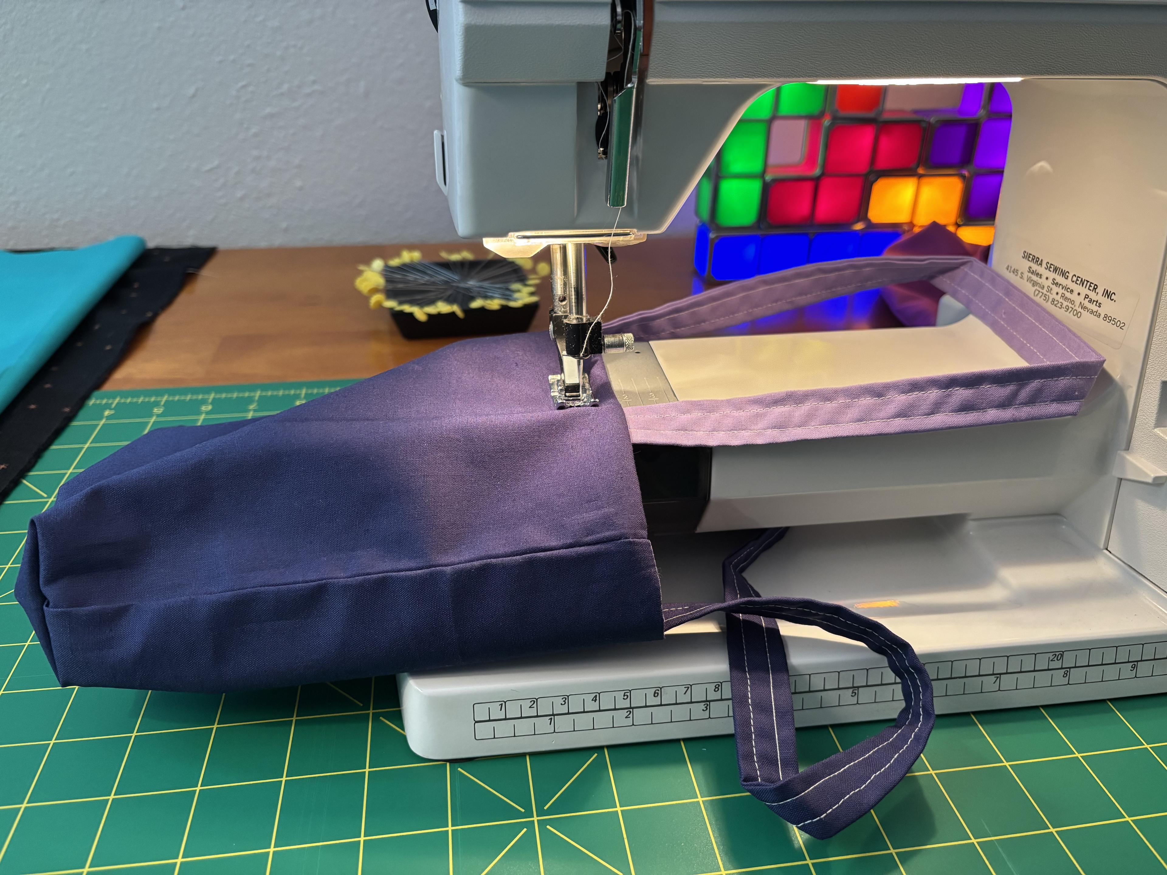 The accessory box is removed from the machine so that I can wrap the bag around the free arm, and sew continuously around the top edge.